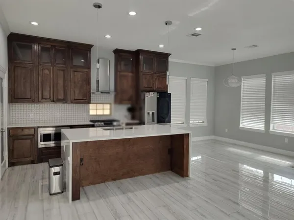 a kitchen with stainless steel appliances granite countertop a stove and a refrigerator
