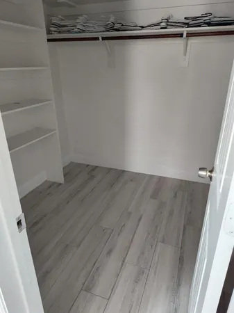 an empty room with a wooden floor and a window