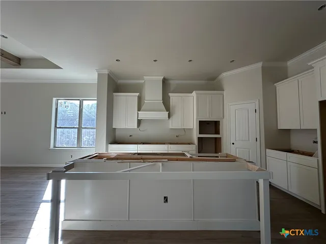 a kitchen with a stove and wooden floor