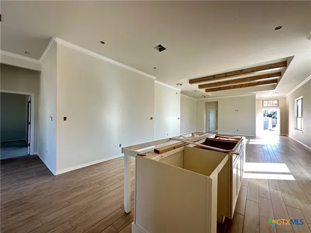 a view of a hallway with wooden floor and windows