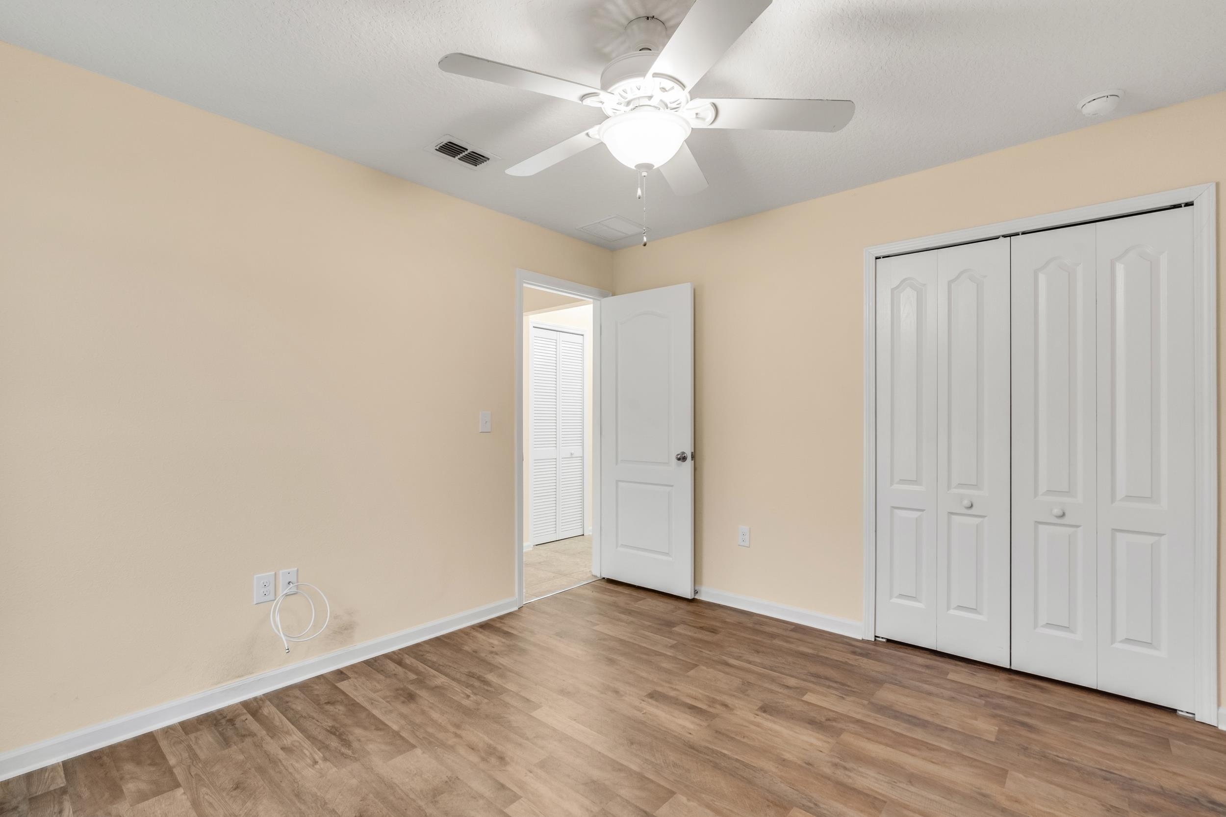 228 Fox Water Trail St. Augustine, FL 32086 - Photo 15 of 50 an empty room with wooden floor and fan