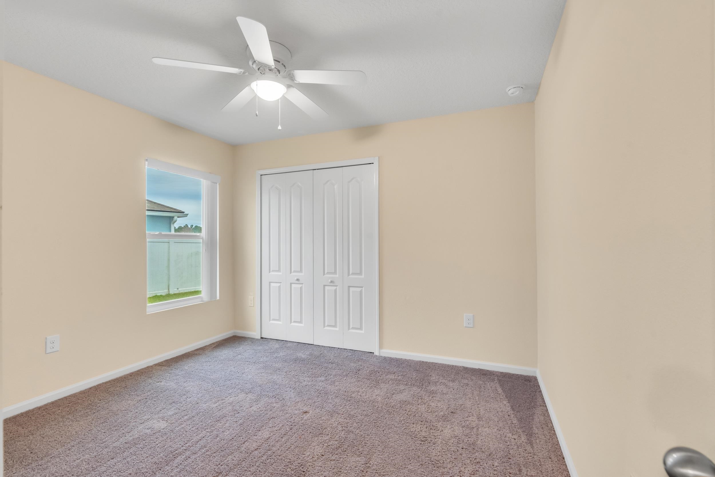 228 Fox Water Trail St. Augustine, FL 32086 - Photo 17 of 50 an empty room with windows and fan