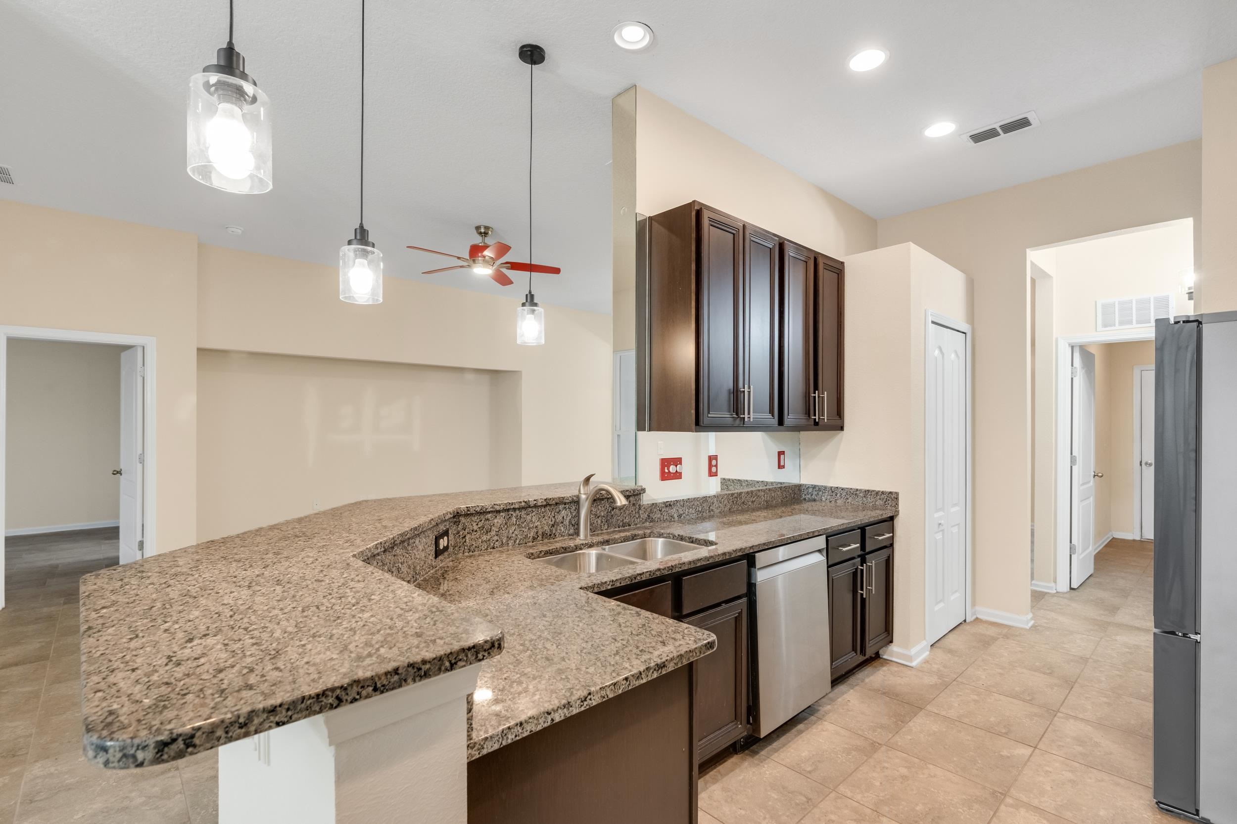 228 Fox Water Trail St. Augustine, FL 32086 - Photo 24 of 50 a kitchen with stainless steel appliances granite countertop a sink and a refrigerator