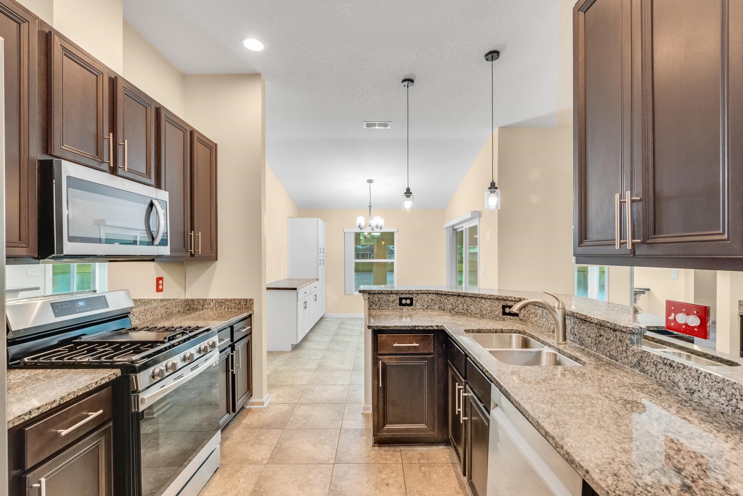 228 Fox Water Trail St. Augustine, FL 32086 - Photo 26 of 50 a kitchen with stainless steel appliances granite countertop a sink stove and cabinets