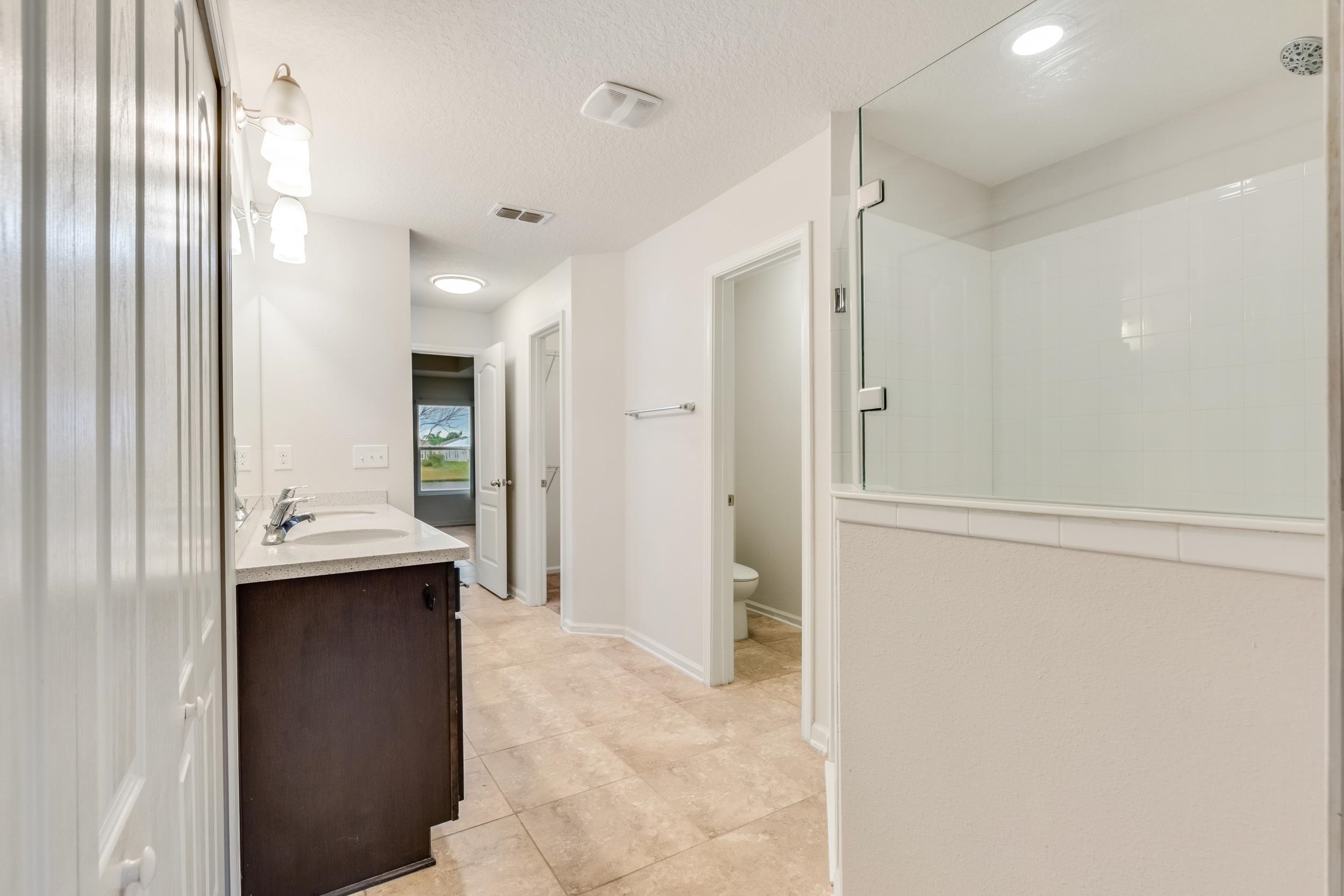 228 Fox Water Trail St. Augustine, FL 32086 - Photo 37 of 50 a bathroom with a sink and mirror with shower