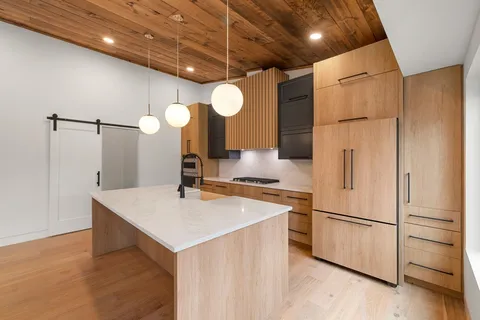 a kitchen with a refrigerator a sink and cabinets