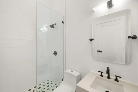 a bathroom with a sink a toilet and shower