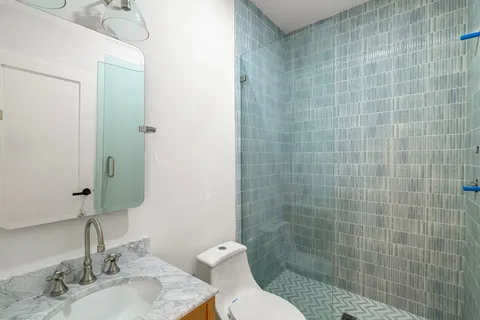 a bathroom with a sink a toilet and shower