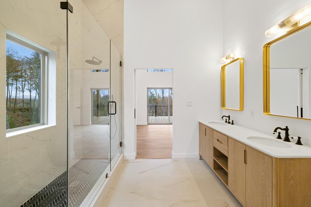 1713 Old Northcutt Road Ellijay, GA 30536 - Photo 37 of 45 a spacious bathroom with a double vanity sink a mirror and a shower