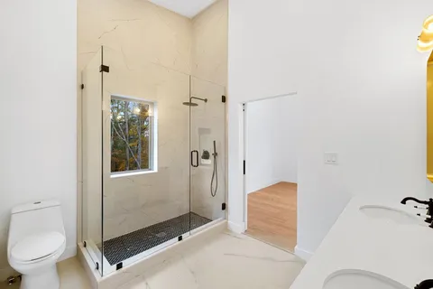 a bathroom with a granite countertop sink toilet and shower
