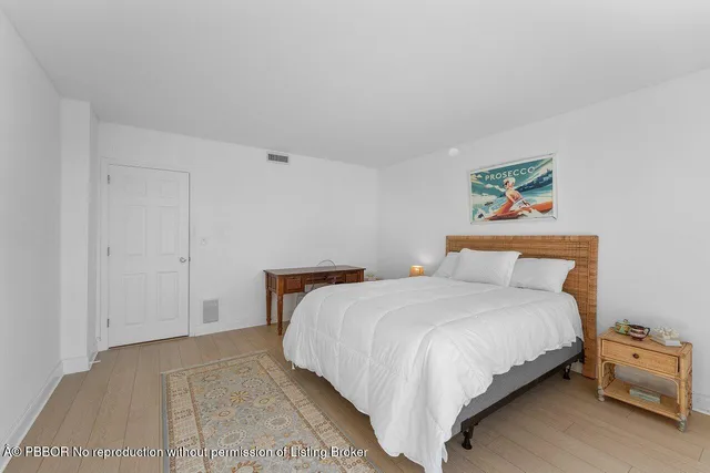 a bedroom with a bed and a painting on the wall