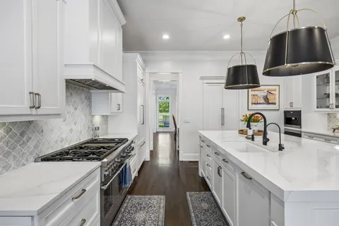 a kitchen with stainless steel appliances kitchen island granite countertop a stove a sink a dining table and chairs with wooden floor