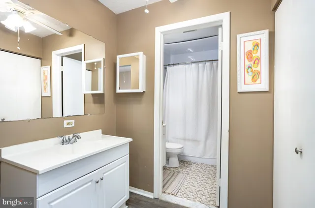 a bathroom with a sink a toilet a shower and a window