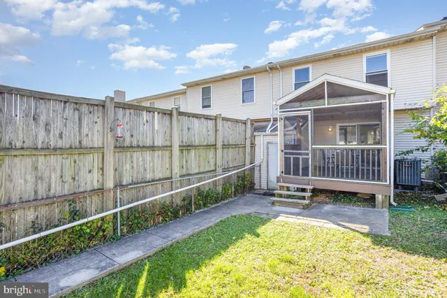 a view of a small house with wooden fence