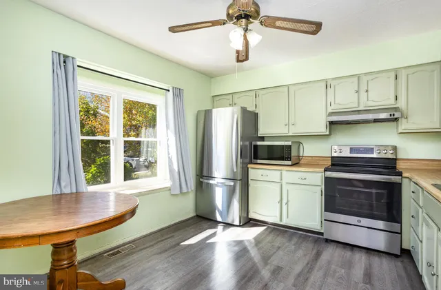 a kitchen with stainless steel appliances a stove a refrigerator and a window