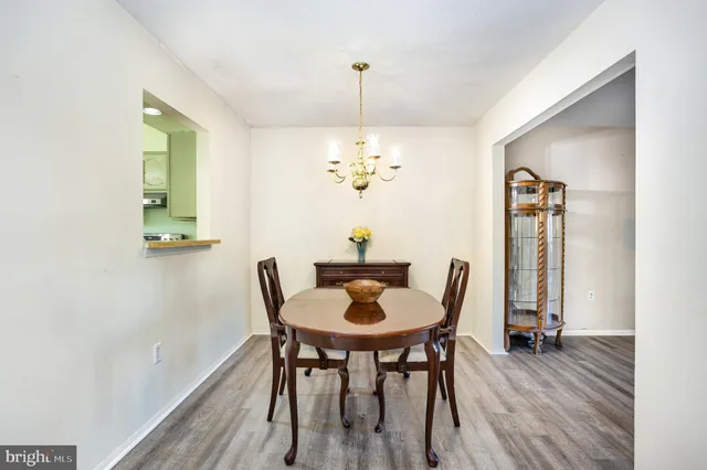 a dining room with furniture a chandelier and wooden floor