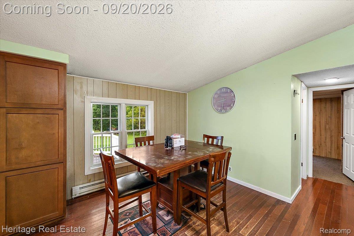 3337 Le Valley Road Columbiaville, MI 48421 - Photo 10 of 57 Hardwood flooring, built-in cabinetry, double-hung window, paneled accent wall, and painted walls