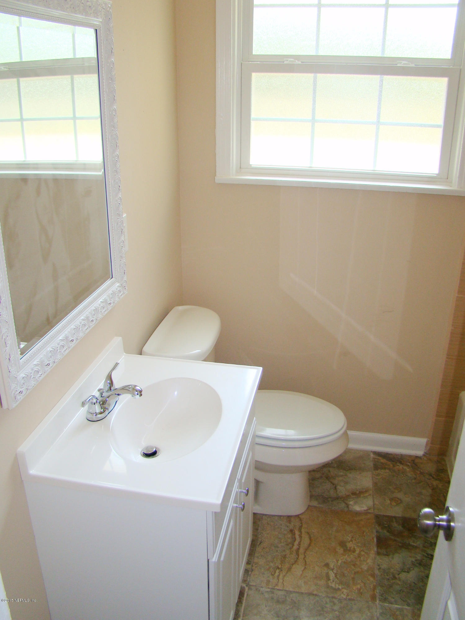 6315 Temple Road Jacksonville, FL 32217 - Photo 11 of 12 a bathroom with a sink a toilet and a window