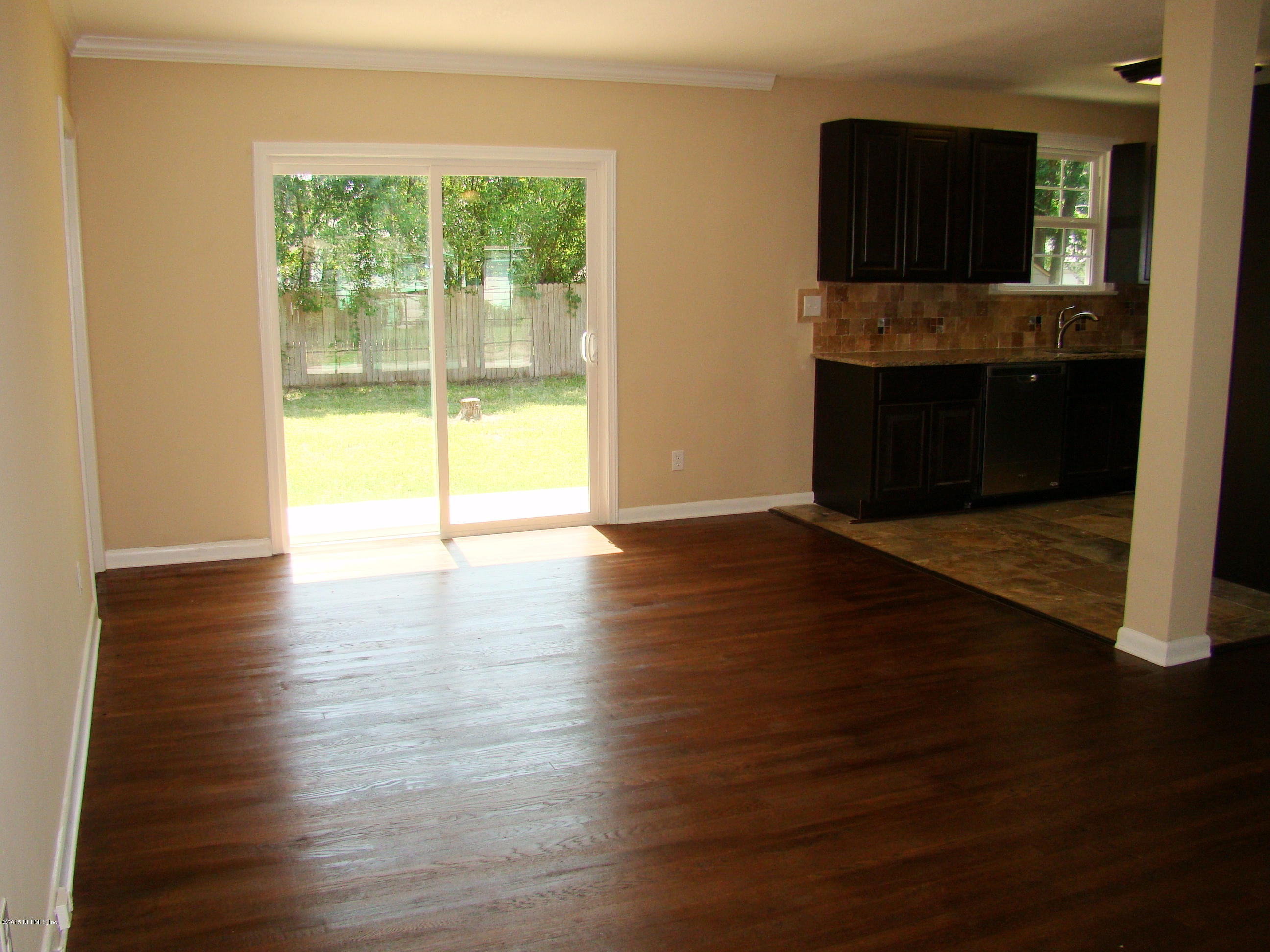 6315 Temple Road Jacksonville, FL 32217 - Photo 2 of 12 a view of an empty room with wooden floor and a window