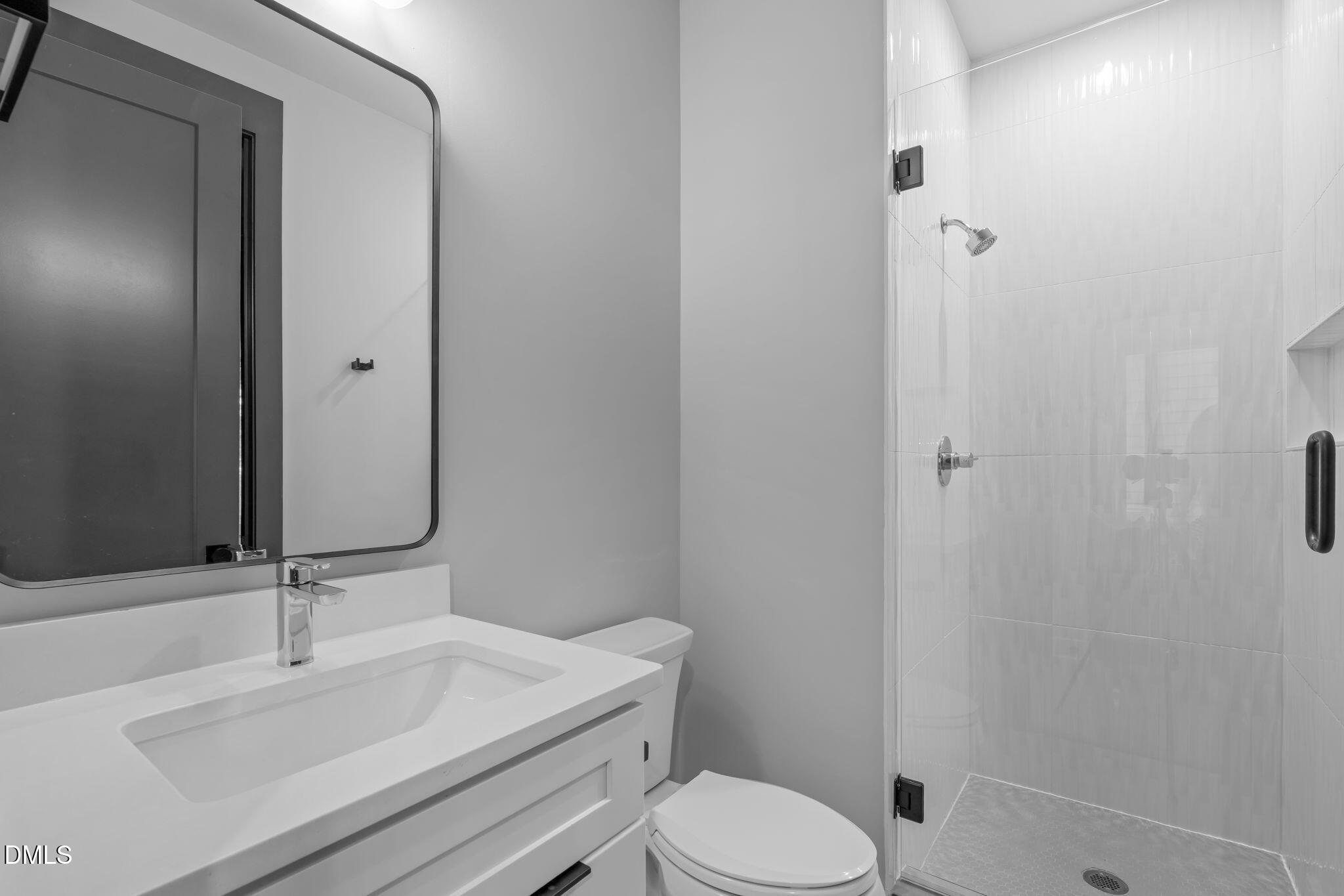 228 Woodsborough Place Raleigh, NC 27601 - Photo 35 of 59 a bathroom with a sink a toilet and shower