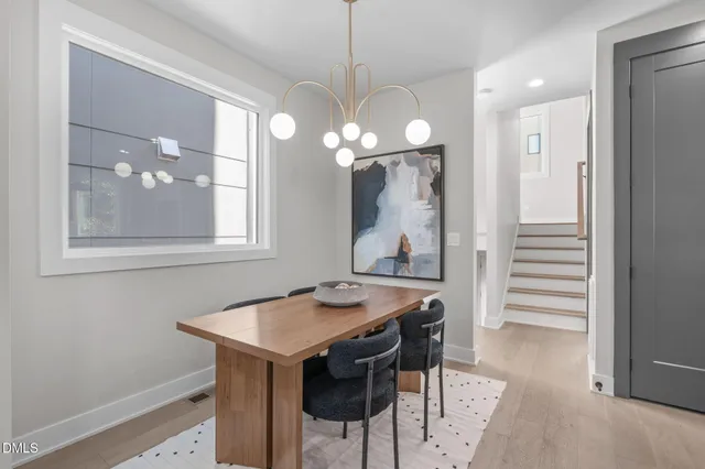 a kitchen with kitchen island a dining table chairs sink and cabinets