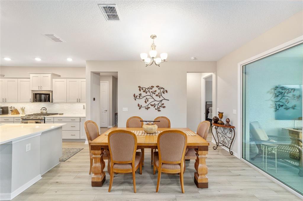 10691 Southwest 99th Place Ocala, FL 34481 - Photo 11 of 52 a view of a dining room with furniture a chandelier and wooden floor