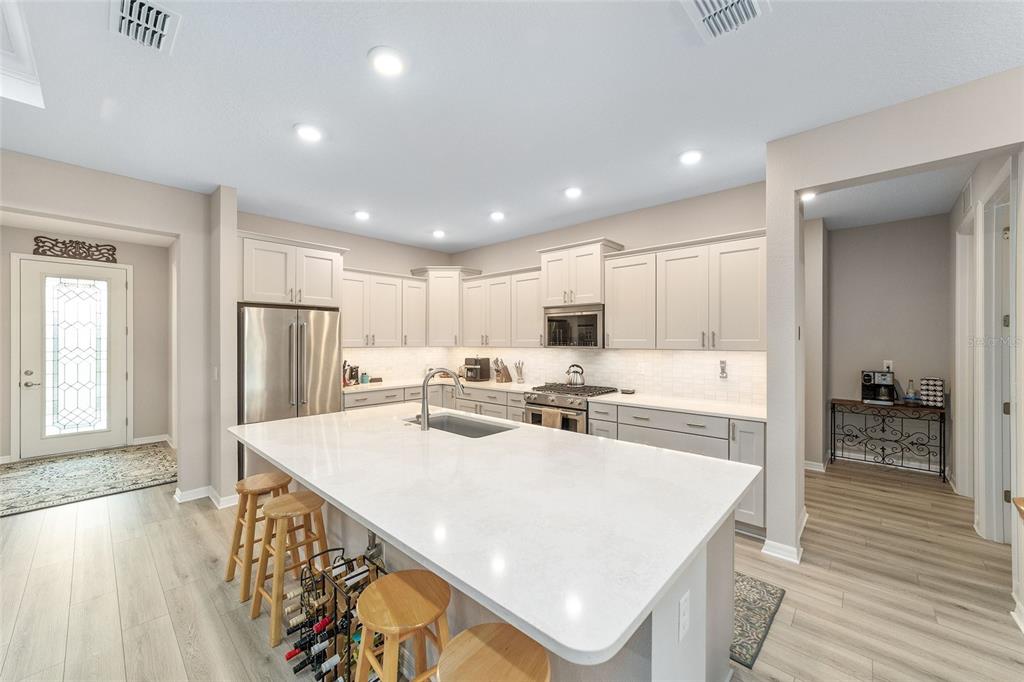 10691 Southwest 99th Place Ocala, FL 34481 - Photo 14 of 52 a large white kitchen with lots of counter space a refrigerator a sink and a stove