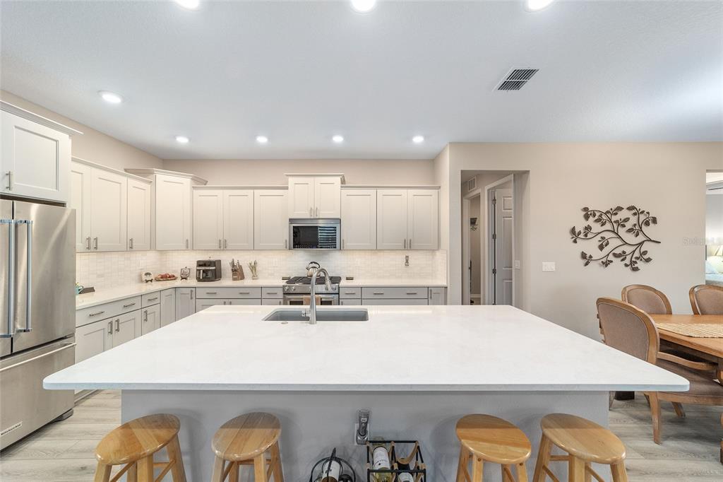 10691 Southwest 99th Place Ocala, FL 34481 - Photo 15 of 52 a large kitchen with sink a refrigerator and white cabinets