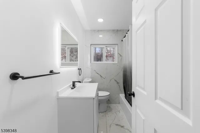 a bathroom with a sink mirror and toilet