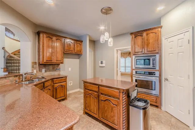 a kitchen with stainless steel appliances granite countertop a refrigerator a stove and a sink with cabinets