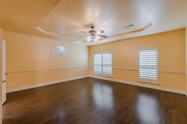 a view of a livingroom with wooden floor and a ceiling fan