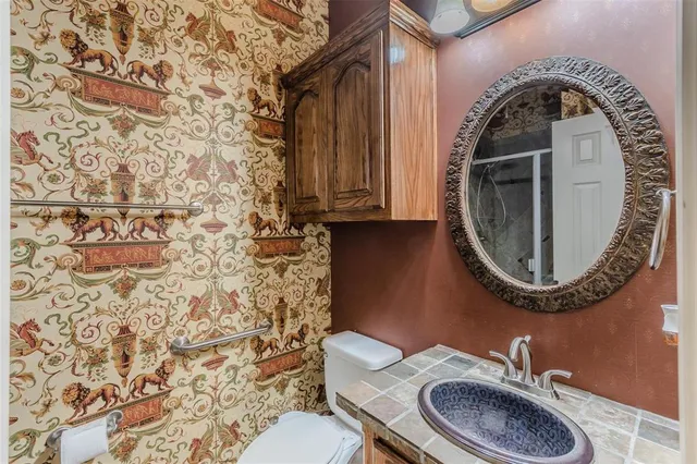 a bathroom with a granite countertop toilet and a sink