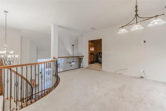 a view of an empty room with a chandelier fan