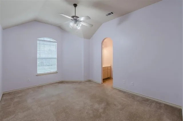 en empty room with windows and chandelier fan