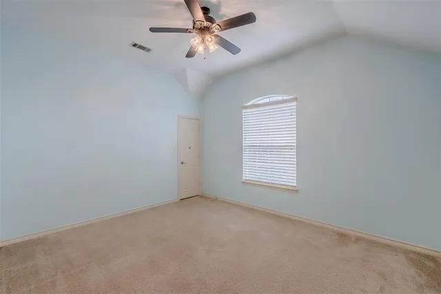 an empty room with windows and fan