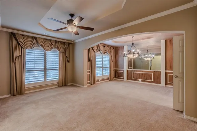 a view of an empty room with a fireplace and a ceiling fan
