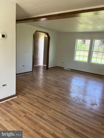 a view of a room with wooden floor and window