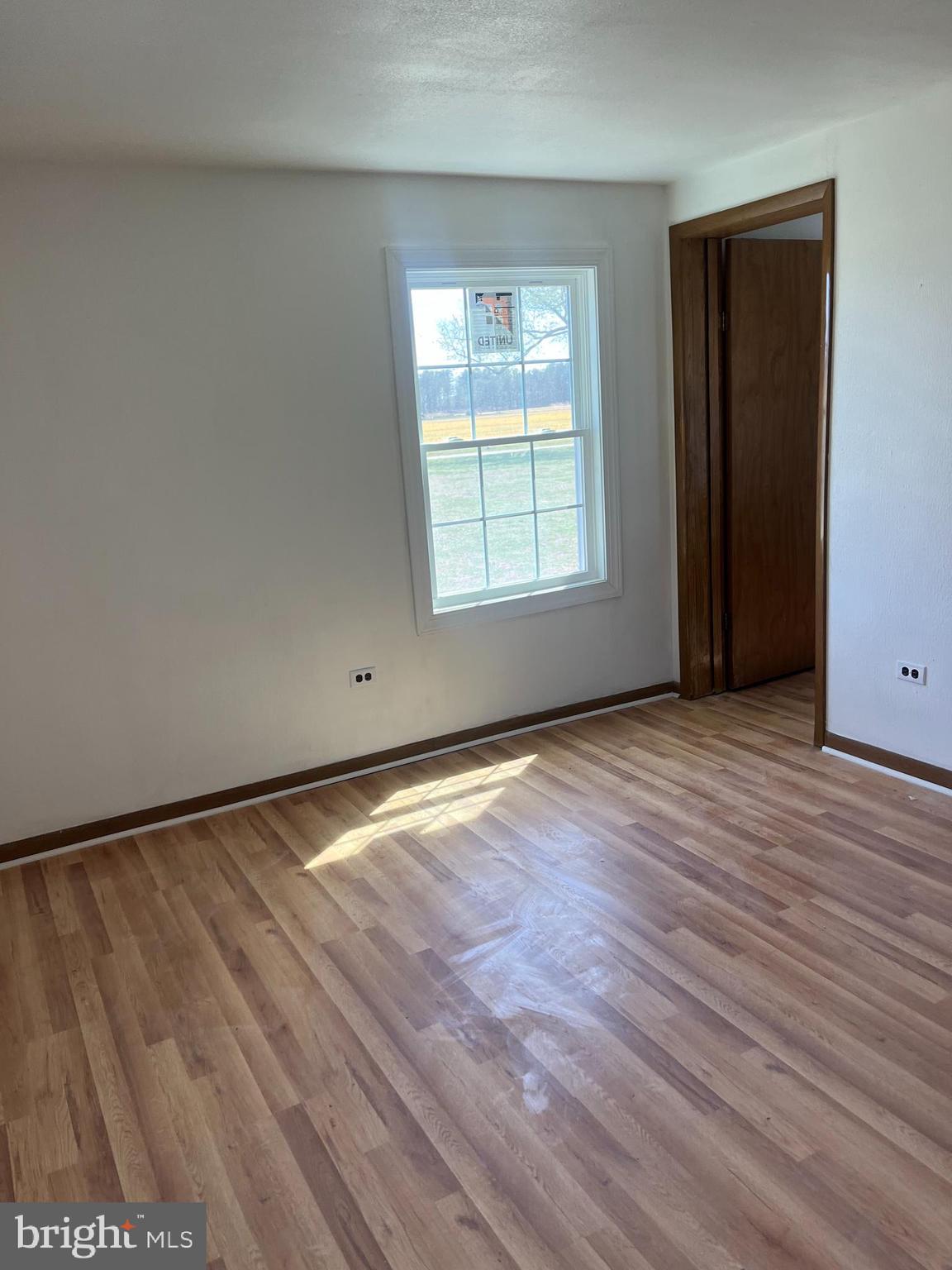 369 Ivey Creek Road Lancaster, VA 22503 - Photo 12 of 31 a view of an empty room with wooden floor and a window