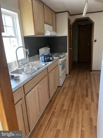 a kitchen with a sink a refrigerator and cabinets