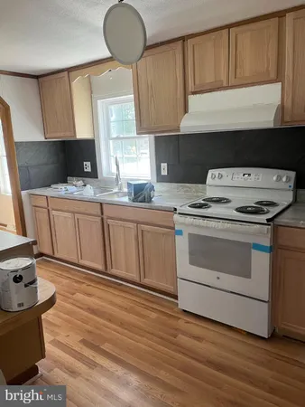 a kitchen with a stove a sink and a microwave
