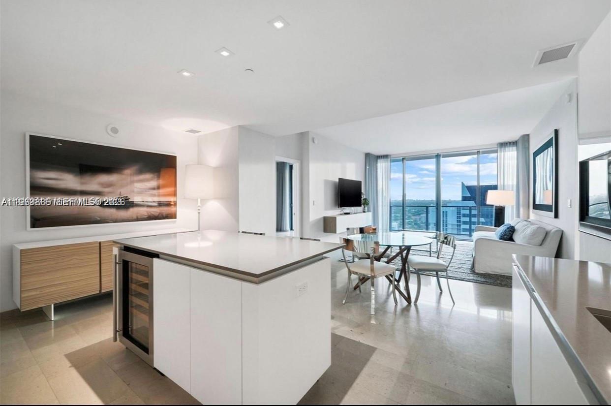 a living room with furniture a flat screen tv and a large window