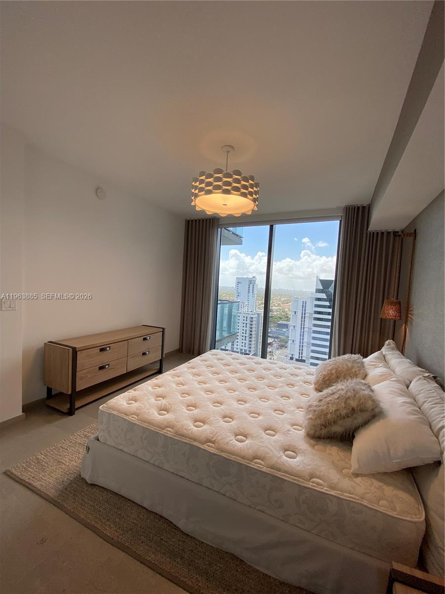 88 Southwest 7th Street, Unit 1904 Miami, FL 33130 - Photo 28 of 33 a bedroom with a bed and a window