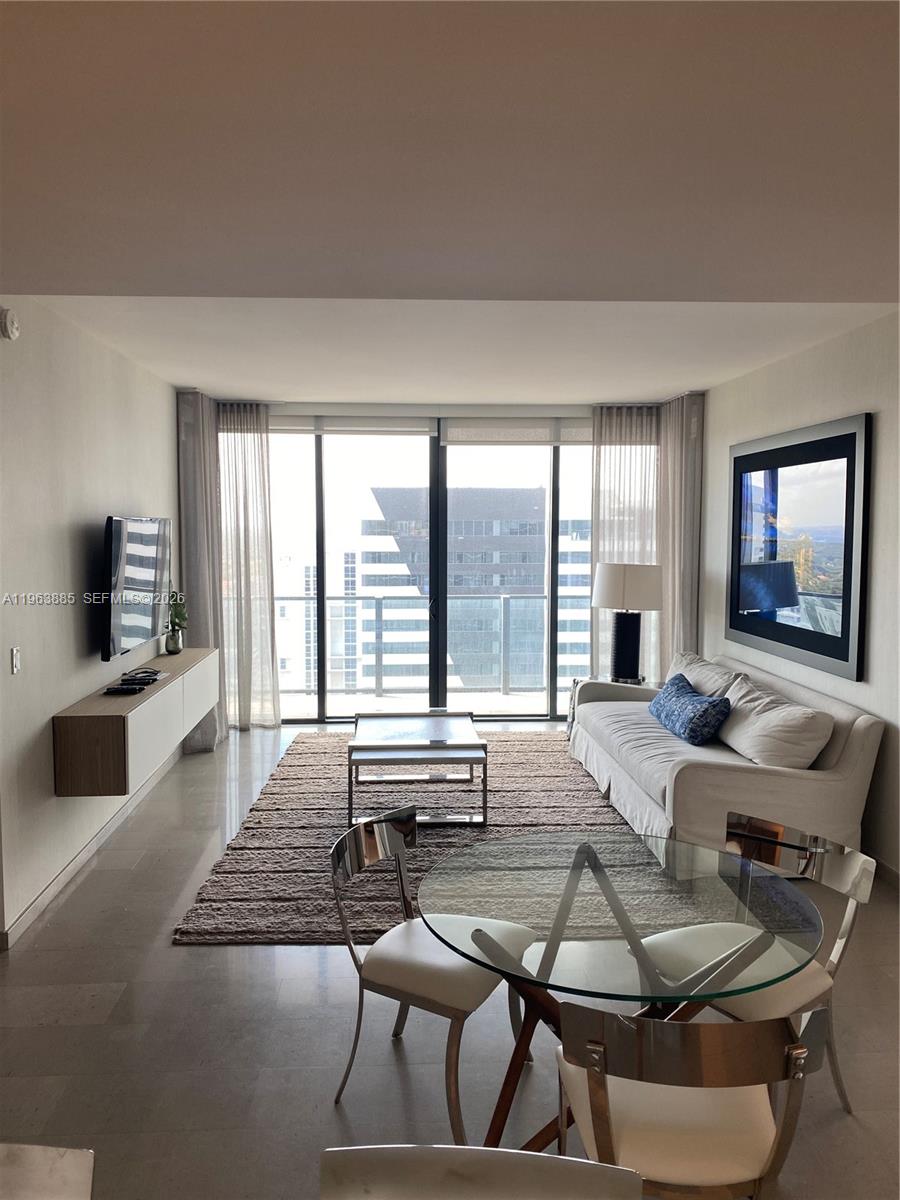 88 Southwest 7th Street, Unit 1904 Miami, FL 33130 - Photo 3 of 33 a living room with furniture and a flat screen tv