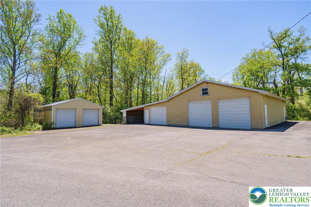 3857 Friedens Road Slatington, PA 18080 - Photo 11 of 75 This property features multiple garage buildings, ideal for storage or workspace amidst a natural setting.