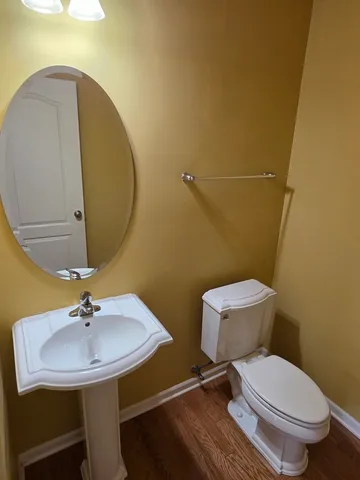 a bathroom with a toilet a sink and mirror