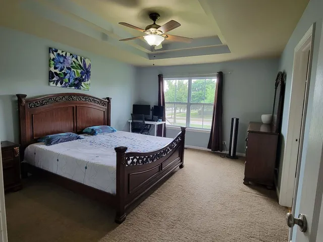 a bed sitting in a bedroom next to a window