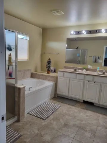 a spacious bathroom with a sink double vanity and a mirror