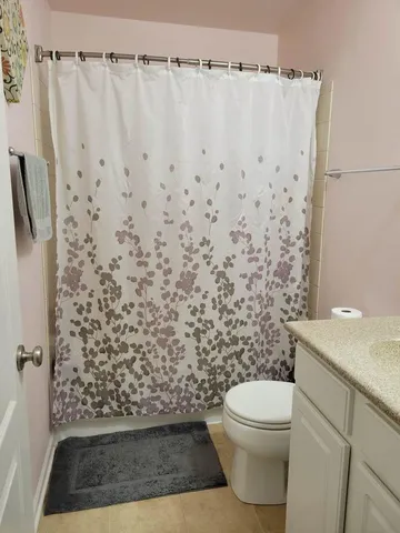 a bathroom with a toilet and a shower curtain