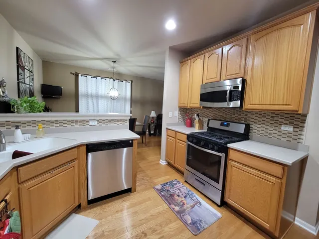 a kitchen with stainless steel appliances kitchen island granite countertop a sink stove and microwave