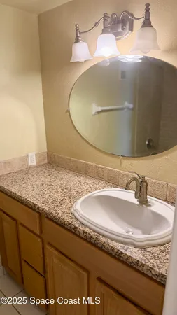 a bathroom with a granite countertop sink and mirror